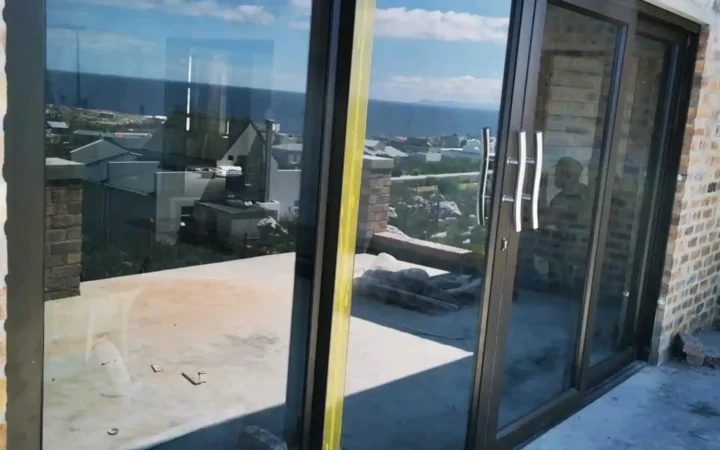 Charcoal aluminium sliding doors overlooking the sea after installation