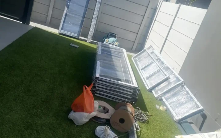 Aluminium door and window frames laid out on the lawn before installation