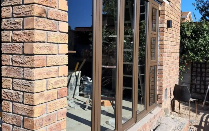 Bronze aluminium doors between face-brick piers