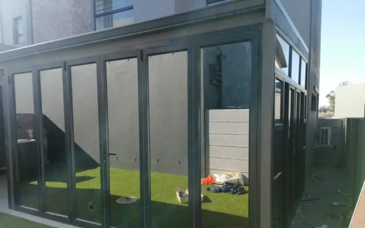 Charcoal aluminium doors closed across a garden room