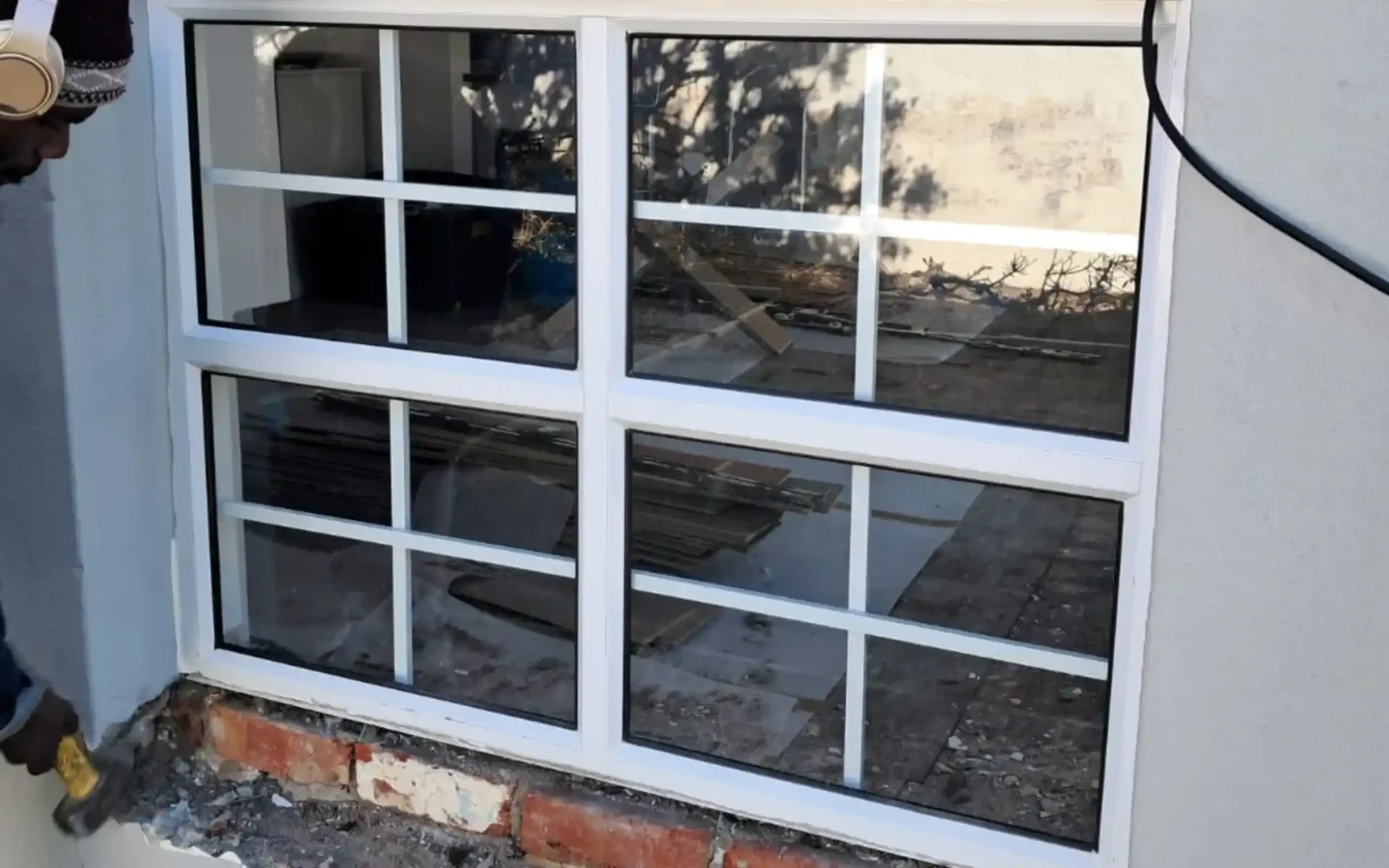 White aluminium windows with glazing bars fitted into a plastered wall