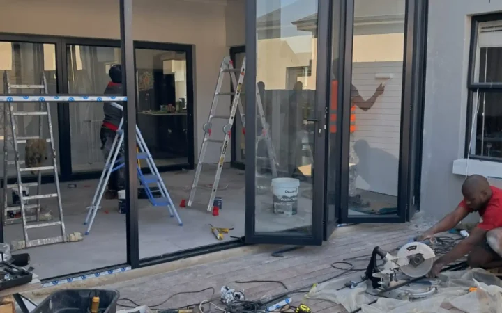 Installers using ladders to fit aluminium stacking doors