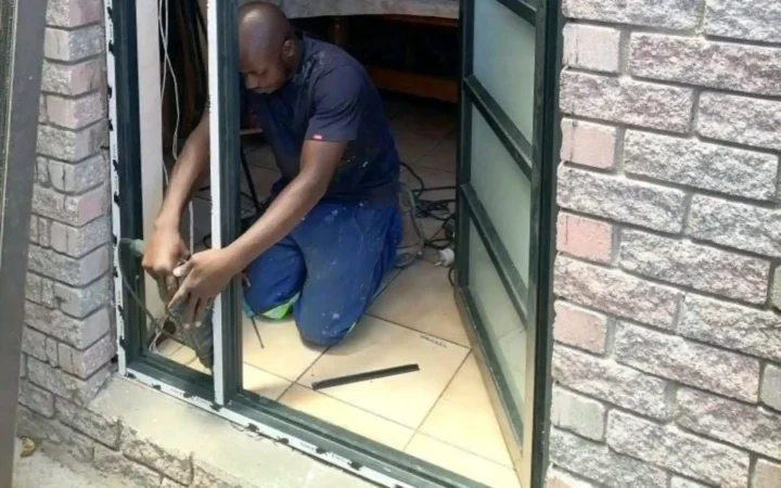 Installer adjusting the hinges of an aluminium folding door